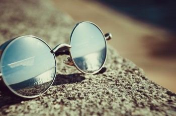 Sunglasses sitting on concrete on sunny day