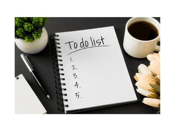 To do List and numbers written on notepad with coffee, small plant and pen around it on a table